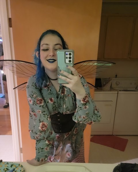 someone wearing a flowy floral print dress and fairy wings