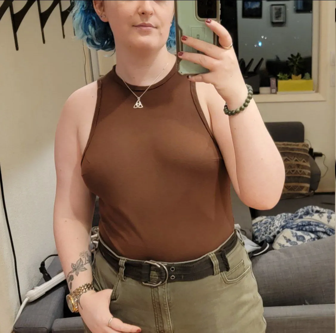 someone wearing a form fitting, high necked, sleeveless brown shirt.