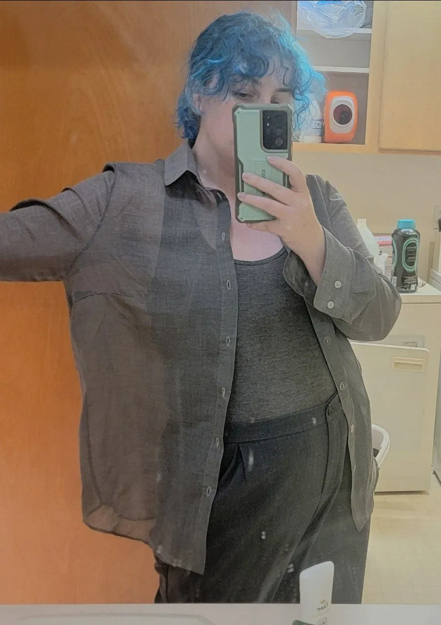 someone wearing a loose and translucent gray collared shirt.
